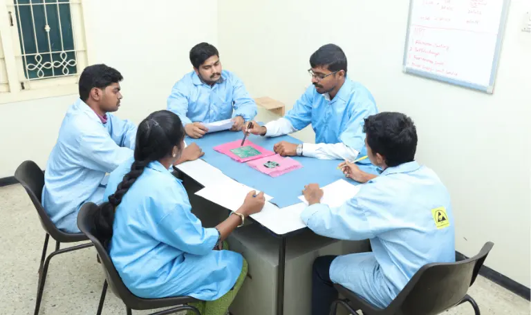 Engineers at Sanjay Technologies discussing PCB prototype designs during an electronics assembly planning session.